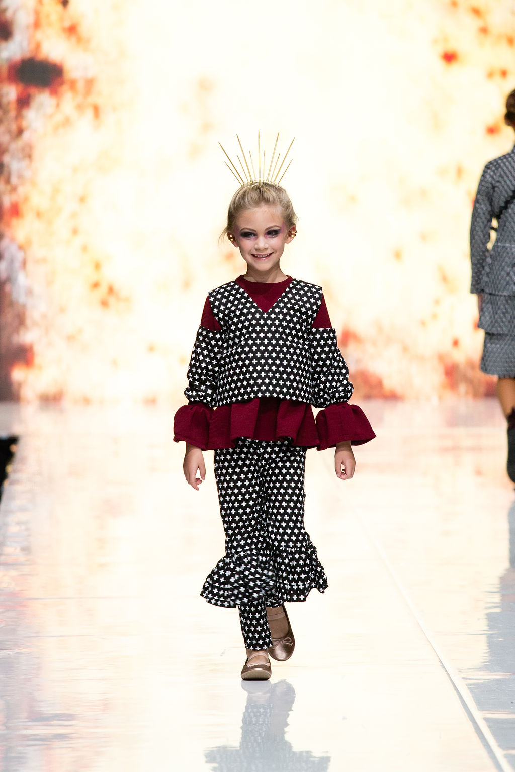 Child walks the runway in the plus print Off-Shoulder Top, ruffle knee pants and burgundy knit top