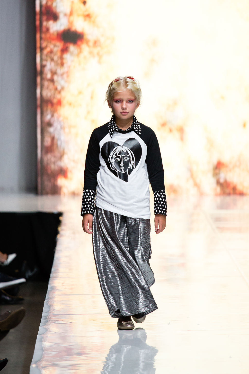 Young lady walks the runway in her Snap Down Top under the Joan T-Shirt with metallic pants