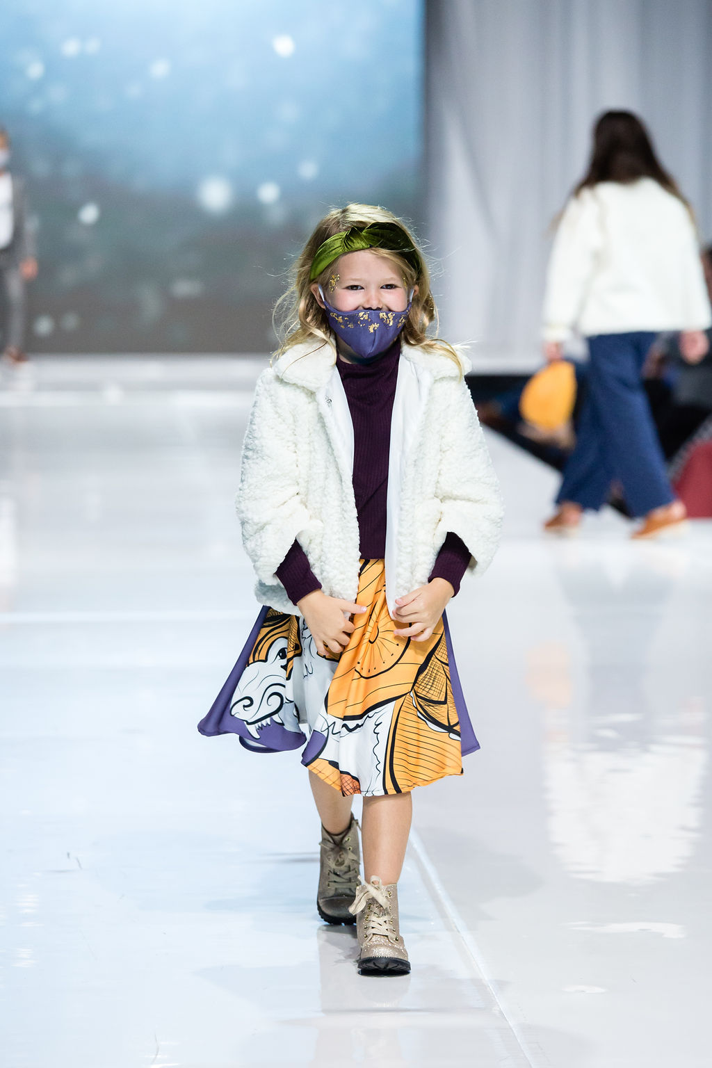 Young lady follows the runway in her purple knit tunic along with a lorek skirt and northern jacket