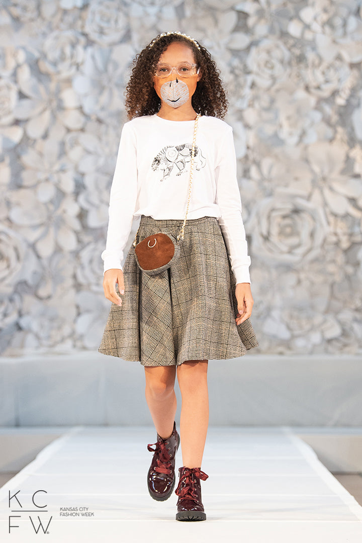 Young lady walking the runway in her lorek shirt paired with a scholars skirt and matching bag