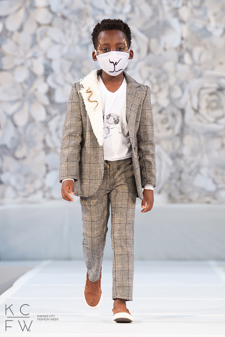 Young man walks the runway in his scholars pants paired with the Asriel Blazer and lorek T-shirt