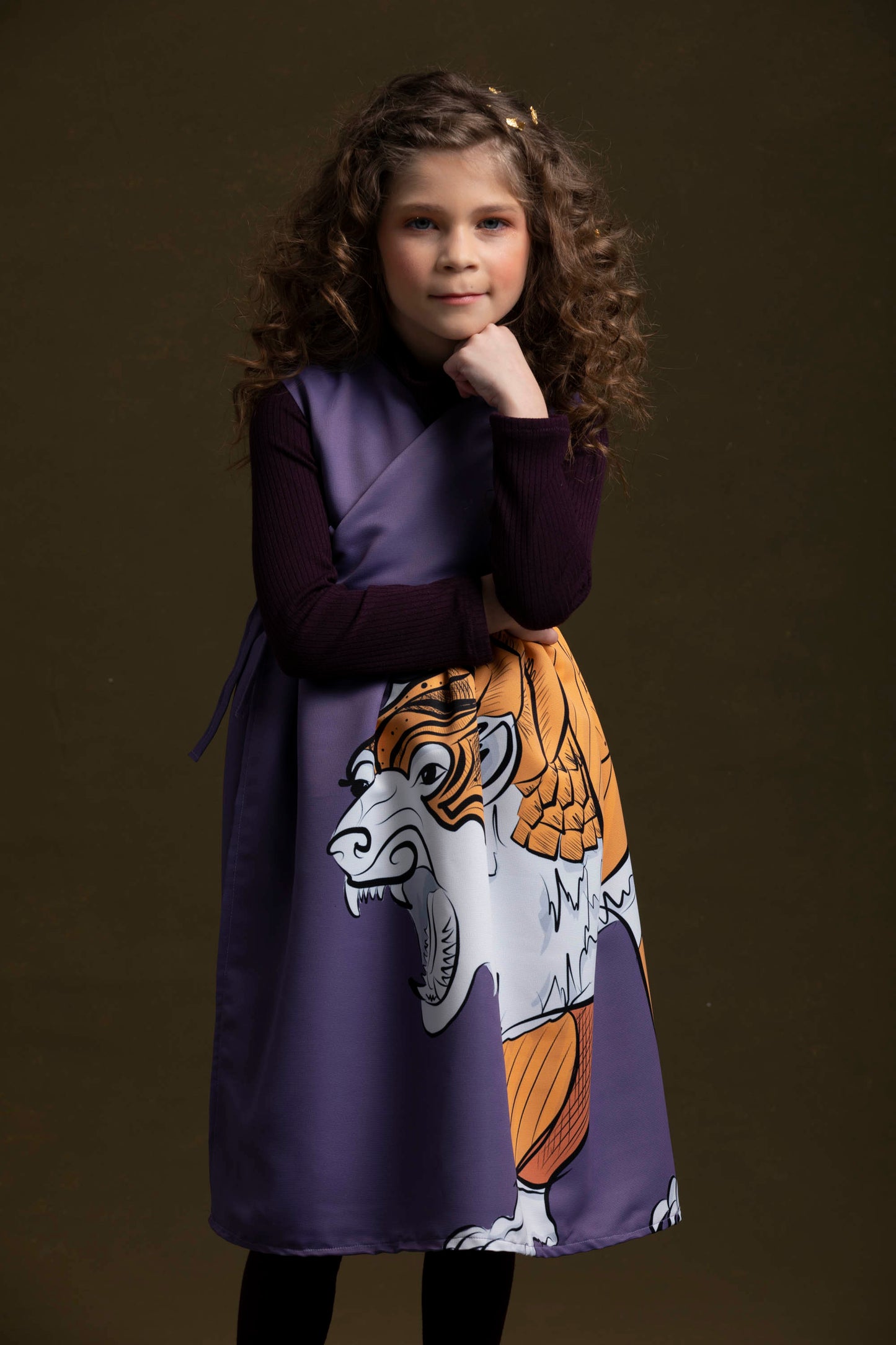 The young sweetheart poses like The Thinker in her purple knit tunic and lorek dress