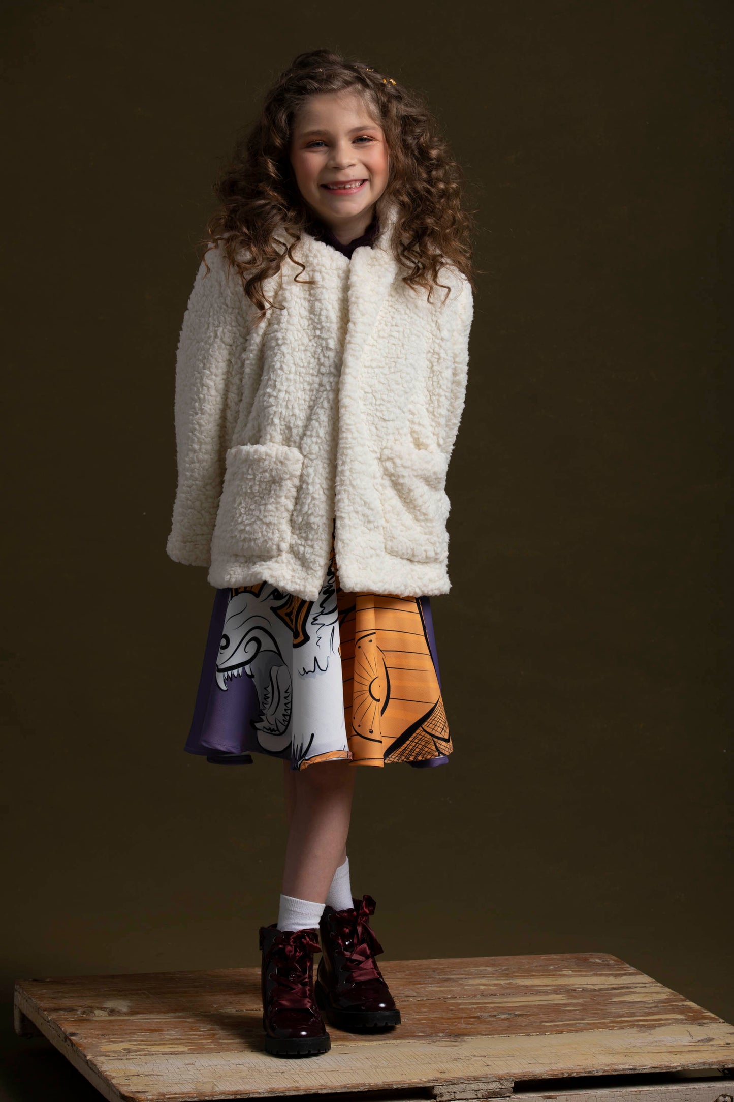 Paired with the lorek skirt and purple knit tunic, she sports her fluffy northern jacket