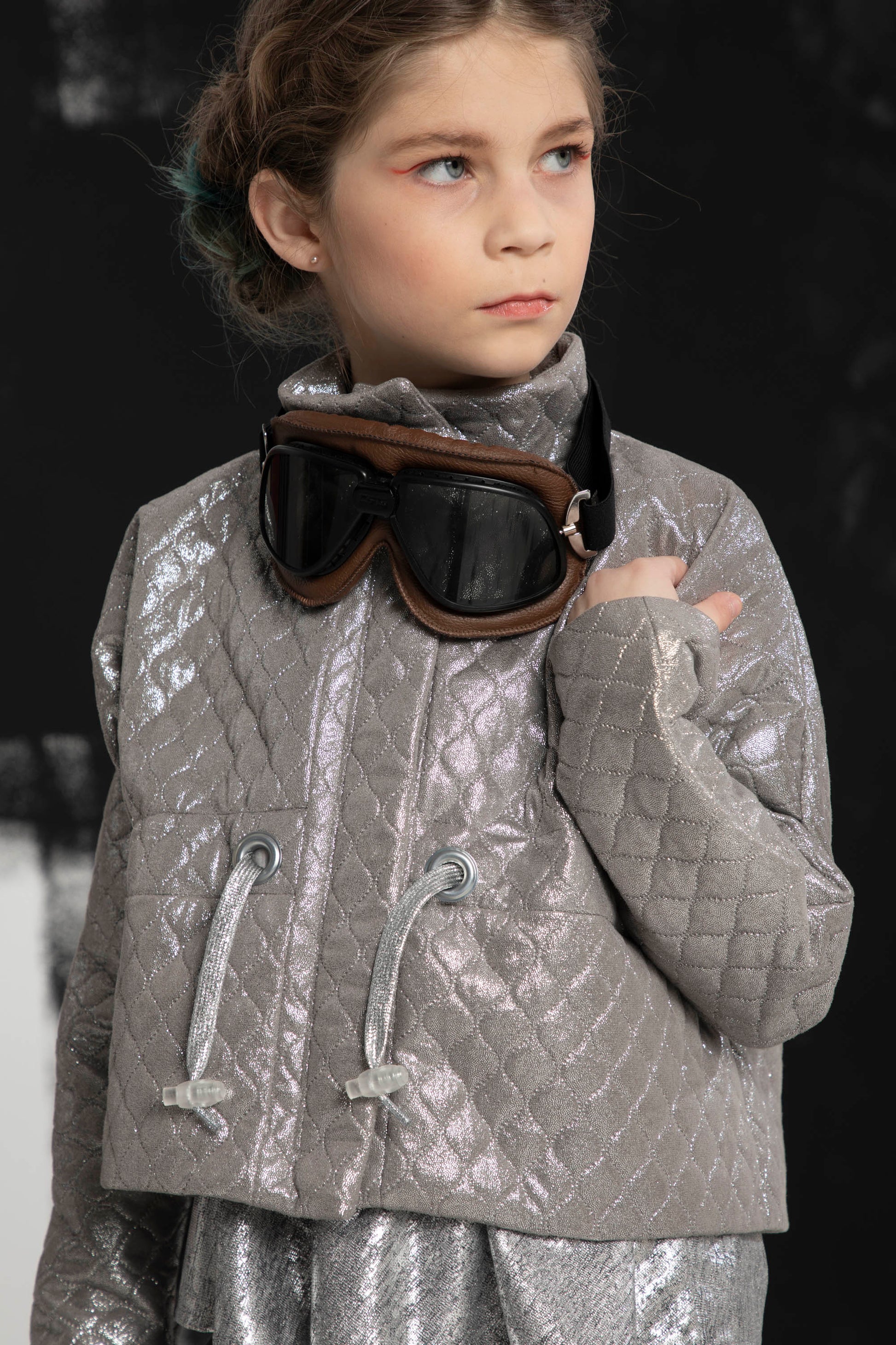 Young girls shows off wearing the Atari Jacket with a cool set of snow goggles around the neck