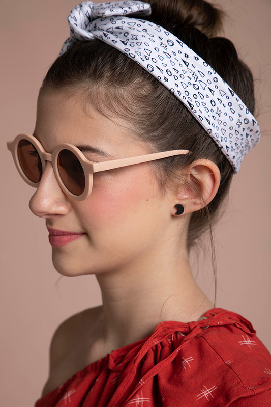 A profile headshot shows this young lady pairing her crescent earrings with her sunnies and headband