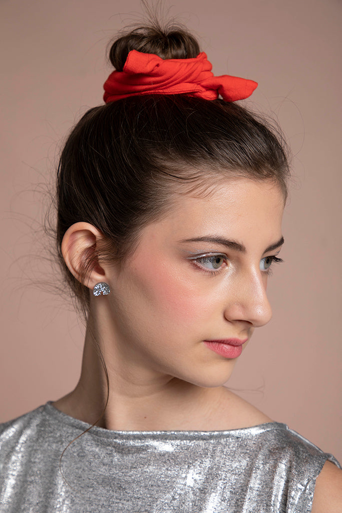 Profile view of a young lady wearing the arch earrings.