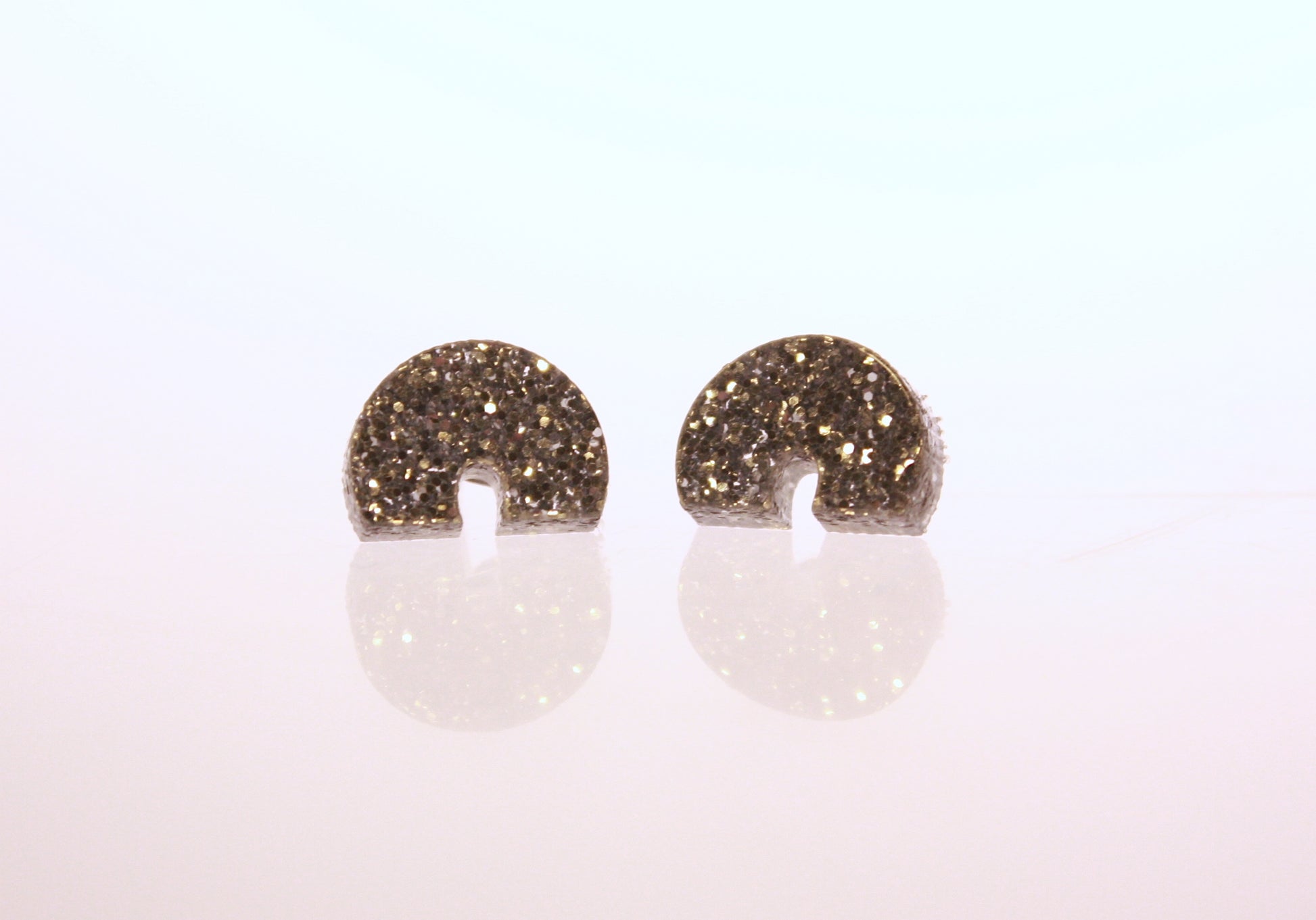 Close up of silver glitter acrylic St. Louis earrings.