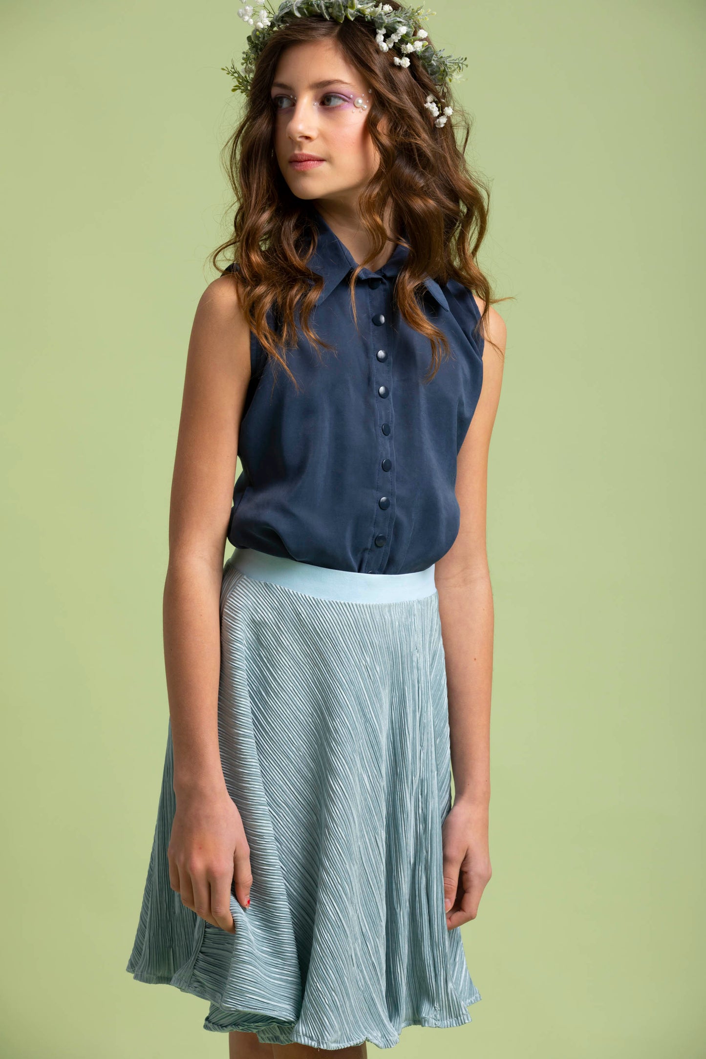 A mid body shot shows us the young girls carmen top paired with her blue crinkle Mercedes Skirt